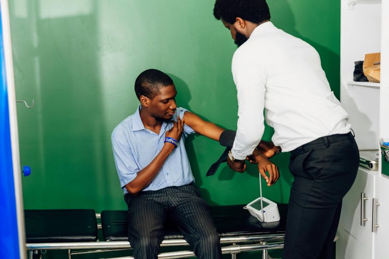 A healthcare professional checks a patient's blood pressure in a clinic in Lagos, Nigeria.